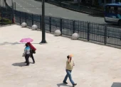 Ciudadanos en el centro de Guayaquil utilizan sombrillas y gorras para protegerse del alto índice de radiación UV que golpea a la urbe.