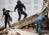 Personas caminan entre los escombros de edificios derrumbados en La Guaira tras los terremotos en Venezuela.