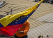 Un integrante de Protección Civil coloca la bandera de Venezuela en La Guaira tras los terremotos