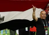 El director técnico de Egipto levanta la bandera nacional durante el partido frente a Argentina.