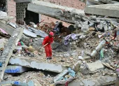 Un trabajador remueve escombros de un edificio colapsado en La Guaira.