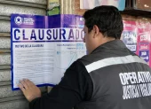 Un funcionario municipal coloca el sello de clausura en uno de los locales intervenidos durante el operativo en el sur de Guayaquil
