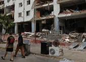 Personas caminan frente a edificios afectados por los terremotos ocurridos en la zona de Caraballeda, en La Guaira (Venezuela).