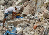 Una persona busca entre los escombros de edificios destruidos por terremotos en Caraballeda.