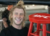 Paddy Pimblett posa junto al asiento que adquirió tras la derrota de Ilia Topuria, combate en el que el hispano-georgiano perdió su invicto como profesional.