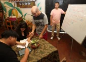 El docente Mauricio Gil (c) da indicaciones a dos jóvenes durante un taller de animación organizado en el centro cultural Casa de Mango, situado en la ciudadela Urdesa.