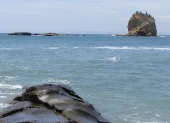 Formaciones rocosas en la costa, mientras la vida marina enfrenta riesgos por el aumento de la temperatura del océano.
