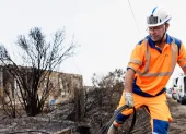 Personal de NGE Energie Solutions asegura las líneas eléctricas frente a viviendas dañadas por el fuego tras los incendios forestales en Le Porge, Francia.