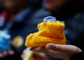 Fotografía del 9 de julio 2026 de una bota de lana para bebé, símbolo de la organización de apoyo para víctimas de adopciones forzadas y tráfico de niños en Chile.