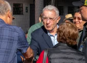 El expresidente (2002-2010), Álvaro Uribe, saluda a un simpatizante a su llegada a un colegio electoral para votar durante la segunda vuelta de las elecciones presidenciales del 21 de junio de 2026.