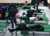 Personas descansan tras ser evacuadas este martes, en Alotenango al suroeste de Ciudad de Guatemala (Guatemala).