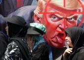 Ciudadanos iraníes caminan junto a una pancarta anti-Trump durante la ceremonia del Día de Arbaeen en las calles de la capital, Teherán, Irán, el 4 de agosto de 2026.