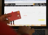 Una persona hace compras en línea usando su tarjeta bancaria.