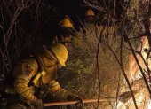 Bomberos trabajan para combatir un incendio forestal cerca de Quito.