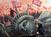Una mujer iraní camina junto a un cartel antiestadounidense en la plaza Enghelab en el centro de Teherán, Irán, el 13 de agosto de 2026.