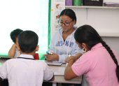 Una maestra junto a jóvenes en un centro de apoyo terapéutico.