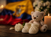 Un osito, unos zapatitos de bebé y una vela encendida simbolizan el duelo perinatal y la memoria de una vida que no llegó a nacer.