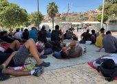 Varios migrantes congregados en los alrededores del Embolsamiento Loma Colmenar, uno de los puntos de acogida, este sábado 22 de agosto en Ceuta.
