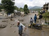 Campesinos avanzan entre el lodo en Trishuli, en el distrito nepalí de Nuwakot, tras una riada repentina.
