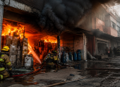 Bomberos enfrentan un incendio en una zona urbana, un escenario que evidencia los riesgos asociados al almacenamiento irregular de materiales inflamables en bodegas clandestinas.