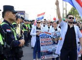 Un grupo de médicos participa en una manifestación en la que exigen dotación en los hospitales y mejores condiciones laborales este viernes, en Cambyretá (Paraguay).