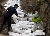 Agentes de la policía nepalí realizan un entierro masivo de víctimas de las inundaciones que golpearon el norte de Nepal.
