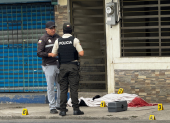 Agentes policiales resguardan la escena del crimen donde fue asesinado un bombero en Machala.