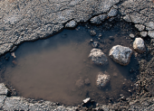 La vía Saracay-Portovelo presenta baches y deterioro mientras soporta el tránsito constante de volquetes con material mineralizado.