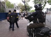 Agente policial custodia el ingreso de estudiantes a un colegio en el norte de Guayaquil.