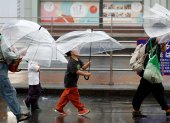 Personas se cubren de las lluvias causadas por el tifón Dujuan en Tokio, Japón.