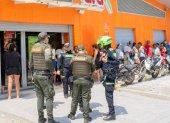 Integrantes de la Policía de Colombia custodian un negocio tras la violencia desatada por las paramilitares ACSN en Santa Marta (Colombia).