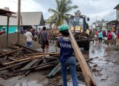 Un miembro de la Marina de México transporta una viga de madera durante la emergencia causada por el huracán Polo en Playa Azul, México, el 24 de septiembre de 2026.