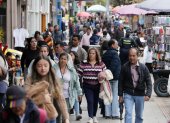 Personas caminan frente a ventas informales este 28 de septiembre de 2026, en Bogotá (Colombia).