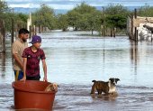Personas cruzan en medio de una inundación causada por el paso de la tormenta tropical Polo en Guaymas al sur de Sonora (México).