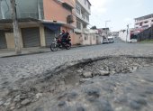 Los baches y el desgaste del asfalto obligan a los conductores a reducir la velocidad y cambiar de trayectoria para continuar por las calles del sector.