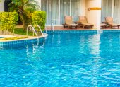 Empty Umbrella and chair around swimming pool in hotel resort