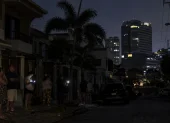 Vecinos permanecen en una calle oscura durante un corte de luz en Guayaquil.