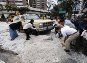 Ciudadanos colaboraron en el retiro del hielo acumulado sobre los vehículos que quedaron cubiertos por la fuerte granizada registrada en Quito.
