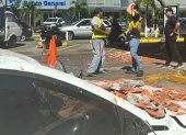 Personas observan un vehículo afectado por los restos de un edificio en Ciudad de Panamá, tras un terremoto de magnitud 7,7 que sacudió el país este viernes 9 de octubre.