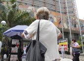Una adulta mayor camina al pie del edificio del Instituto Ecuatoriano de Seguridad Social.