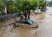 Una persona se refugia sobre un vehículo afectado por un aluvión, el jueves 8 de octubre de 2026, en la comuna de Las Condes, en Santiago de Chile.