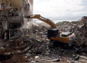 Fotografía que muestra una retroexcavadora durante el proceso de demolición de edificios afectados por el terremoto en Cali.