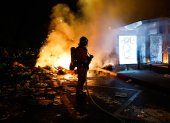 Un bombero francés interviene ante barricadas en llamas en una calle.