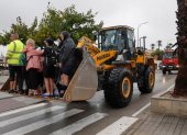 Un grupo de personas permanecen en la pala de una excavadora tras ser rescatadas este lunes en Oliva.