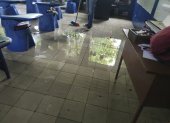 Un trabajador de una escuela en Guayaquil intenta retirar el agua acumulada en un aula.
