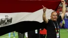 El director técnico de Egipto levanta la bandera nacional durante el partido frente a Argentina.