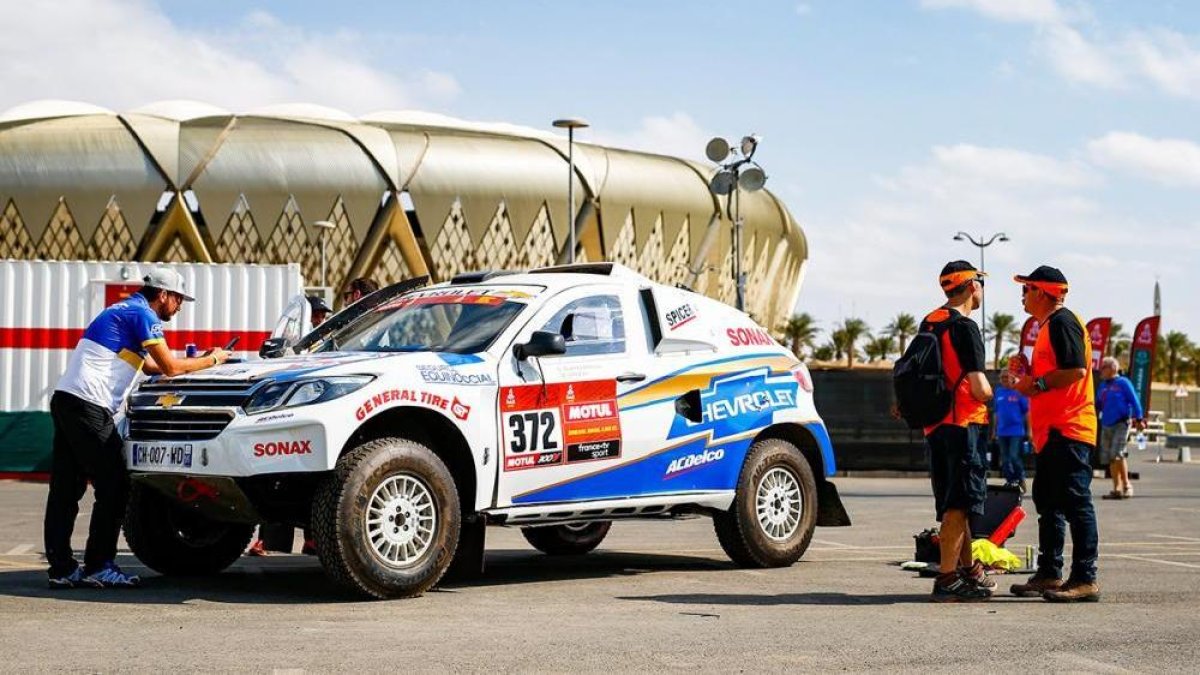 El piloto ecuatoriano Sebastián Guayasamín (i) junto al auto con el que competirá en el rally Dakar a desarrollarse en Arabia Saudita.