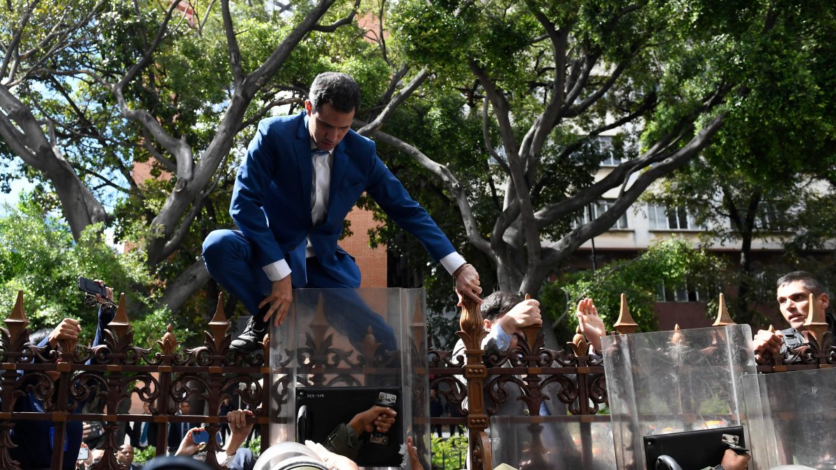 Guaidó intentó trepar las rejas del edificio legislativo, pero militares con escudos antimonines le impidieron saltar.