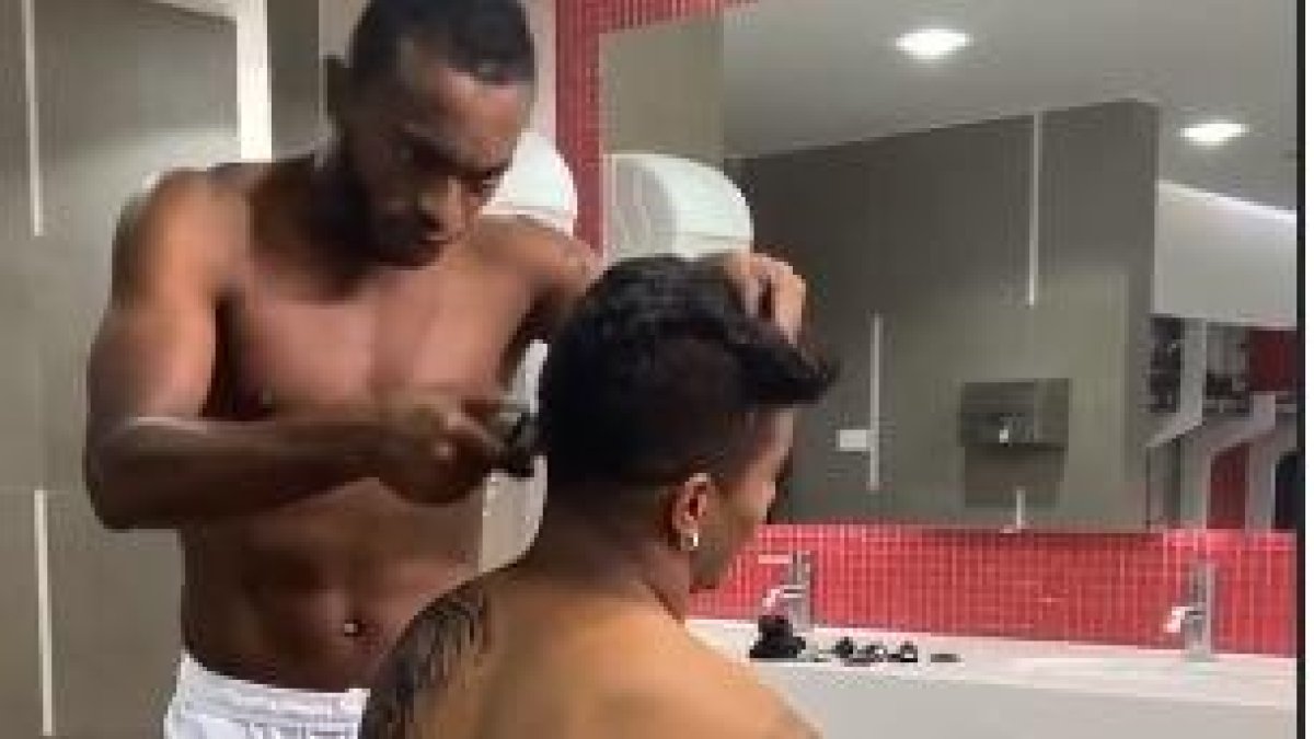 Pedro Pablo Perlaza corta el cabello de un compañero antes de la sesión de fotos para un auspiciante.