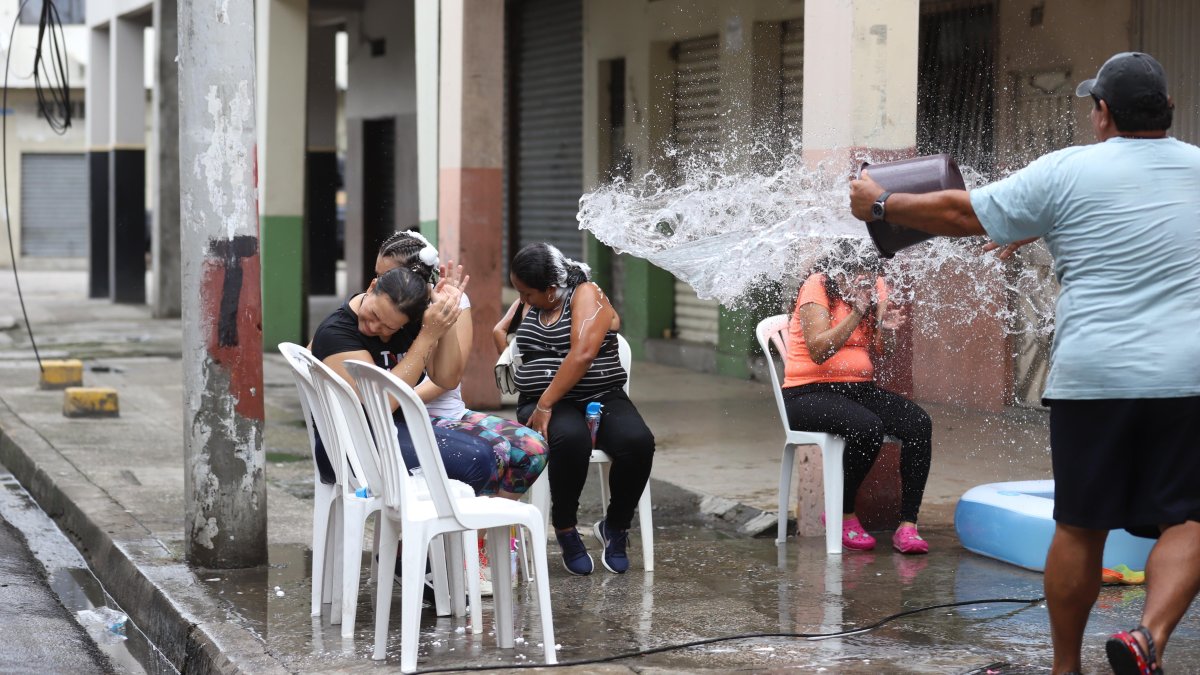 Una persona juega con agua potable, por el carnavaL, en el centro de Guayaquil.